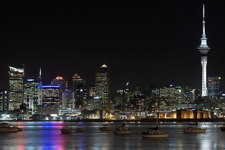 Discover Auckland's iconic skyline illuminated at night as you explore historic sites and scenic points at your own pace with a self-guided audio tour. Uncover the city's rich heritage and beauty.